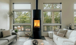 Poêle à bois colonne Fonte Flamme Linia allumé dans un salon lumineux