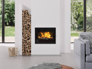 Insert à bois Dovre 2320 SCB à grande vitre dans une cheminée blanche, séjour lumineux