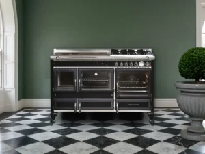 Cuisinière mixte Archambaud Légende 140 noire et chrome dans une cuisine de maison de campagne anglaise, sol en damier de marbre