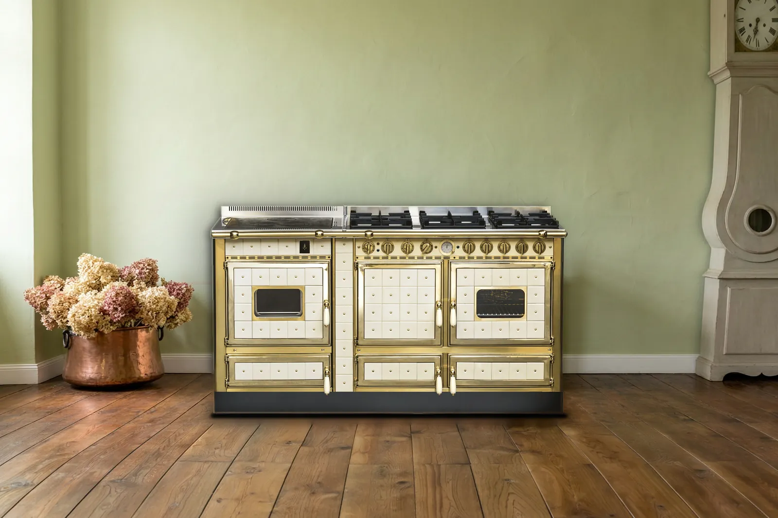 Cuisinière mixte Archambaud Origine 160 en faïence crème et laiton dans une cuisine de maison du Val de Loire, parquet de chêne et horloge comtoise