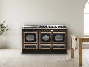 Cuisinière mixte Archambaud Prestige 160 noire et bronze dans une cuisine scandinave, sol clair et table en chêne