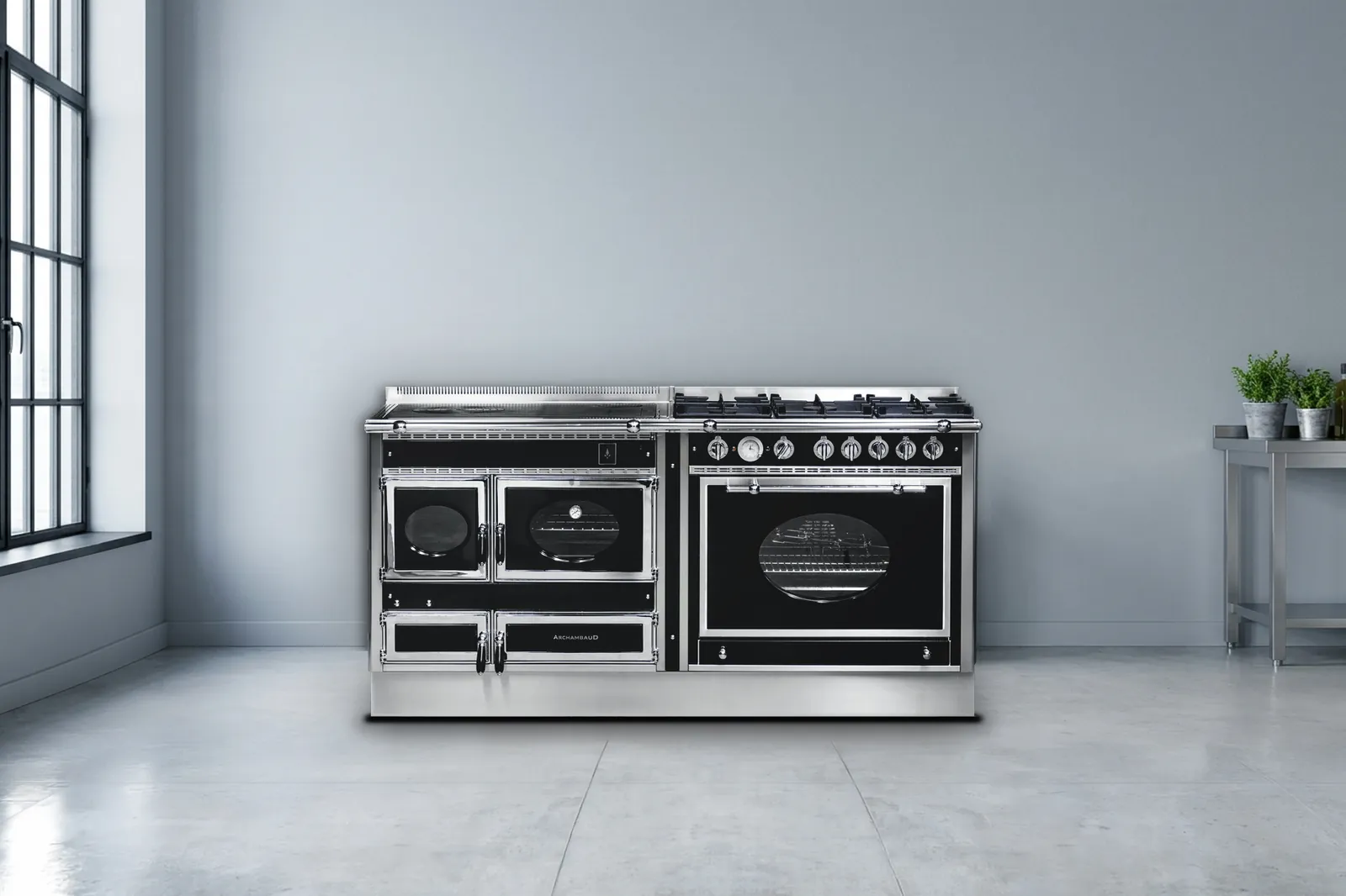 Cuisinière mixte Archambaud Prestige 180 noire et inox dans une cuisine de loft industriel, béton ciré et fenêtre d’atelier