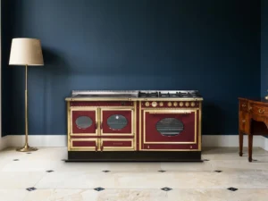 Cuisinière mixte Archambaud Prestige 190 émaillée bordeaux et laiton dans une cuisine de manoir, mur bleu nuit et sol en pierre