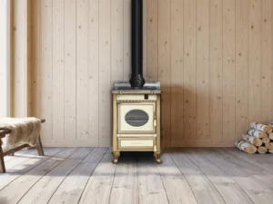 Cuisinière à bois Archambaud Prestige 60 crème et laiton dans une cuisine de chalet alpin, murs en lambris de bois clair