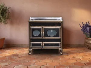 Cuisinière à bois Archambaud Prestige 90 noire et bronze dans une cuisine de mas provençal, tomettes hexagonales en terre cuite