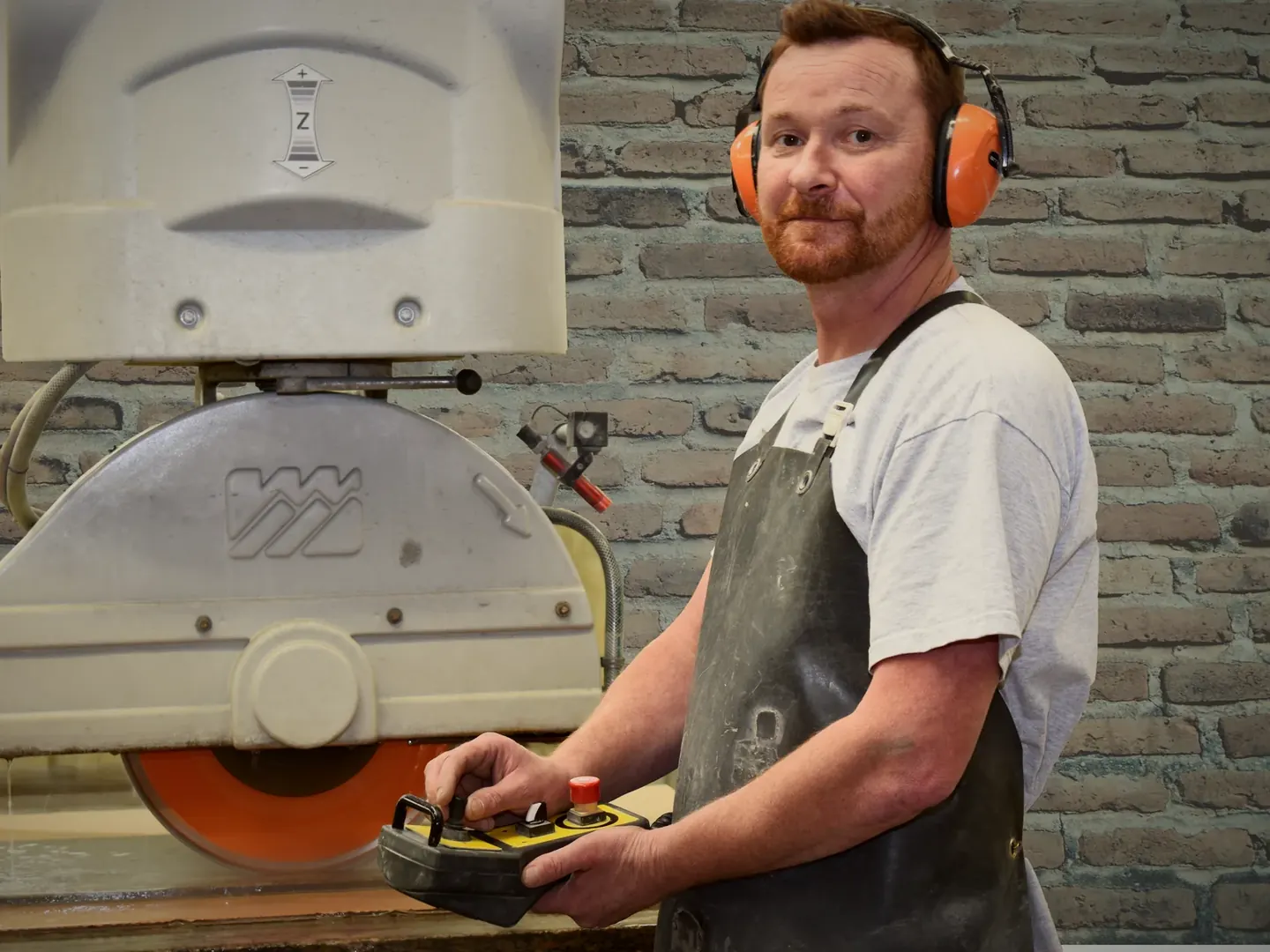 Notre marbrier à la scie dans l’atelier de marbrerie Cheminées Jouvin à Vitré