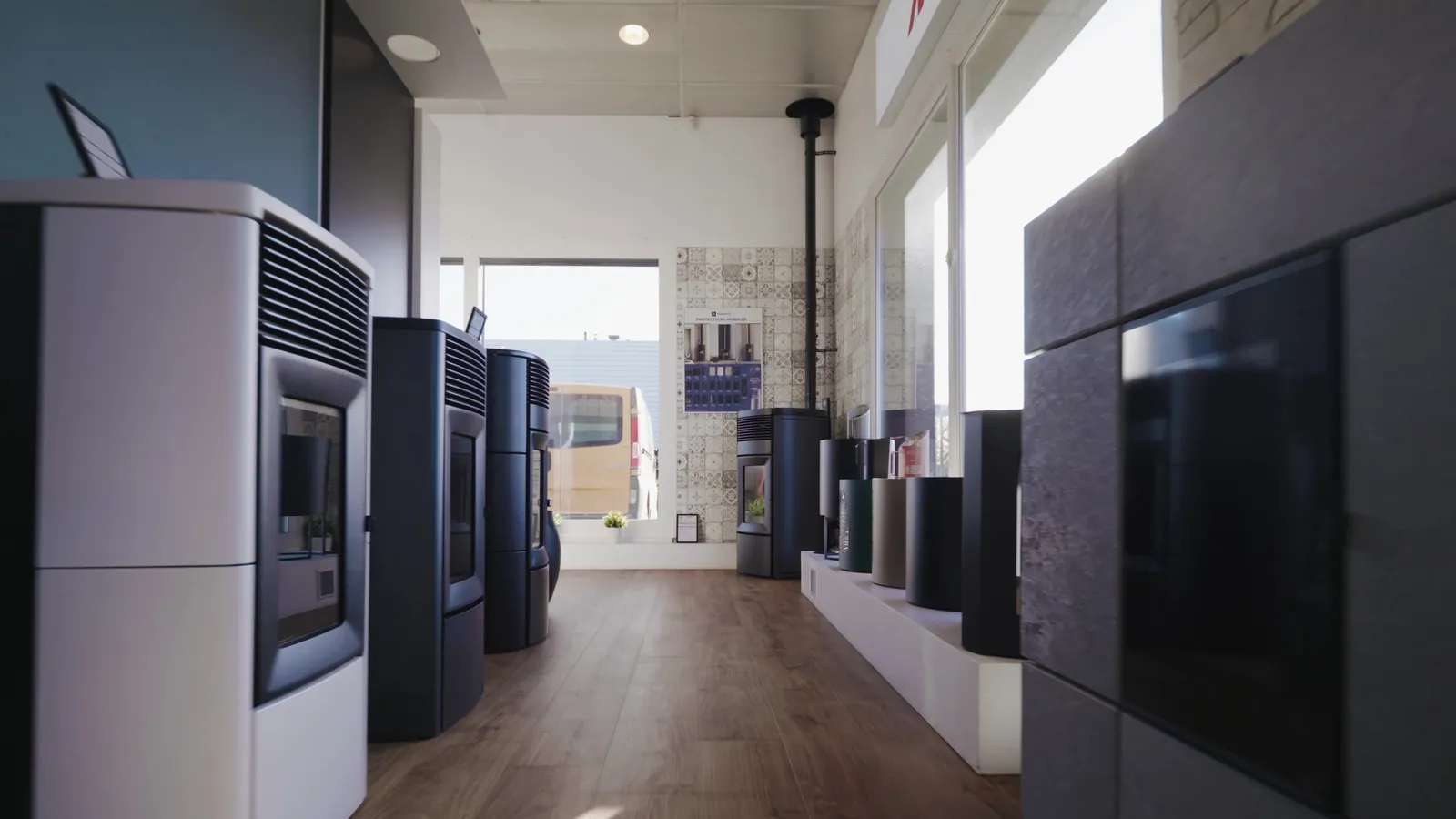 Allée des poêles à granulés baignée de lumière au showroom de Vitré