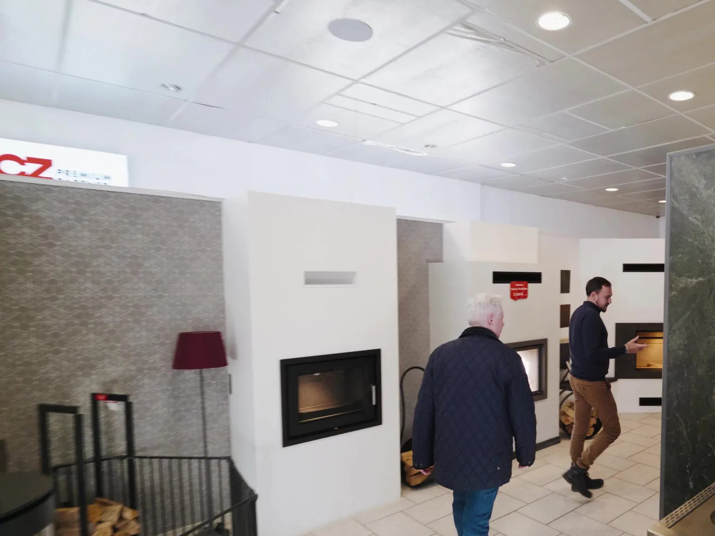 Un conseiller Cheminées Jouvin accompagne un client dans le showroom de Vitré