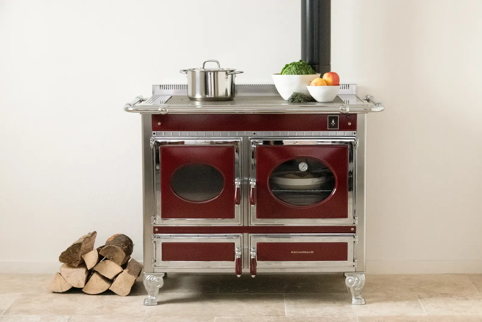 Cuisinière à bois Prestige 100 bordeaux et chrome avec foyer vitré, four à bois et plaque coup de feu en fonte