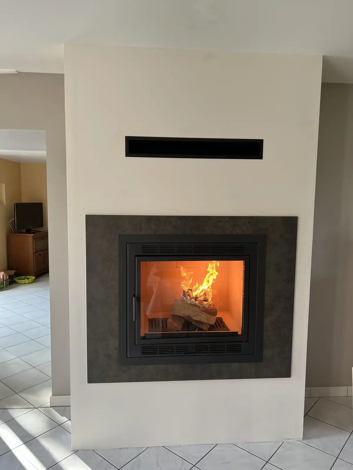 Insert sur-mesure, cadre céramique corten — réalisation Cheminées Jouvin, cheministe à Vitré (35) Insert sur-mesure, cadre céramique corten — réalisation Cheminées Jouvin, cheministe à Vitré (35)