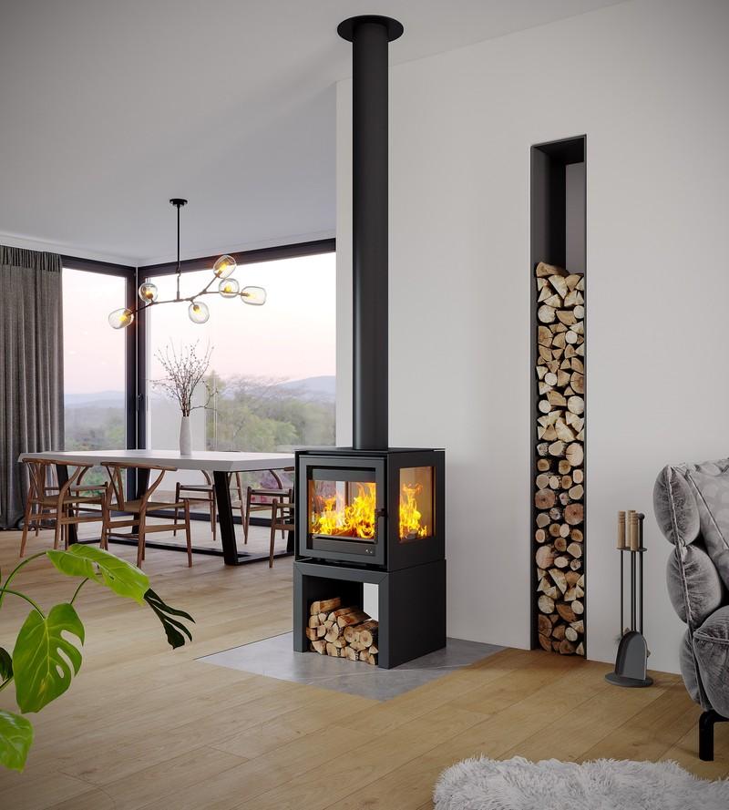 Poêle-cheminée Totem Ambel 500 allumé entre séjour et salle à manger, rangement de bois vertical
